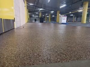 A very large underground parking garage with a concrete floor — San Leandro, CA — Mission Flooring and Countertop Design