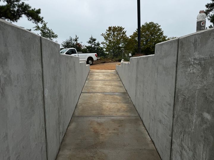 A white truck is parked on the side of a concrete walkway.