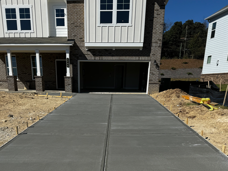 A concrete driveway is being built in front of a house.