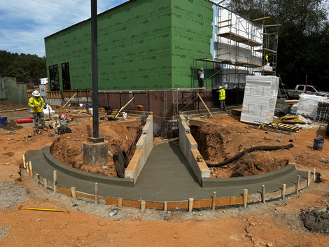 A construction site with a green building in the background