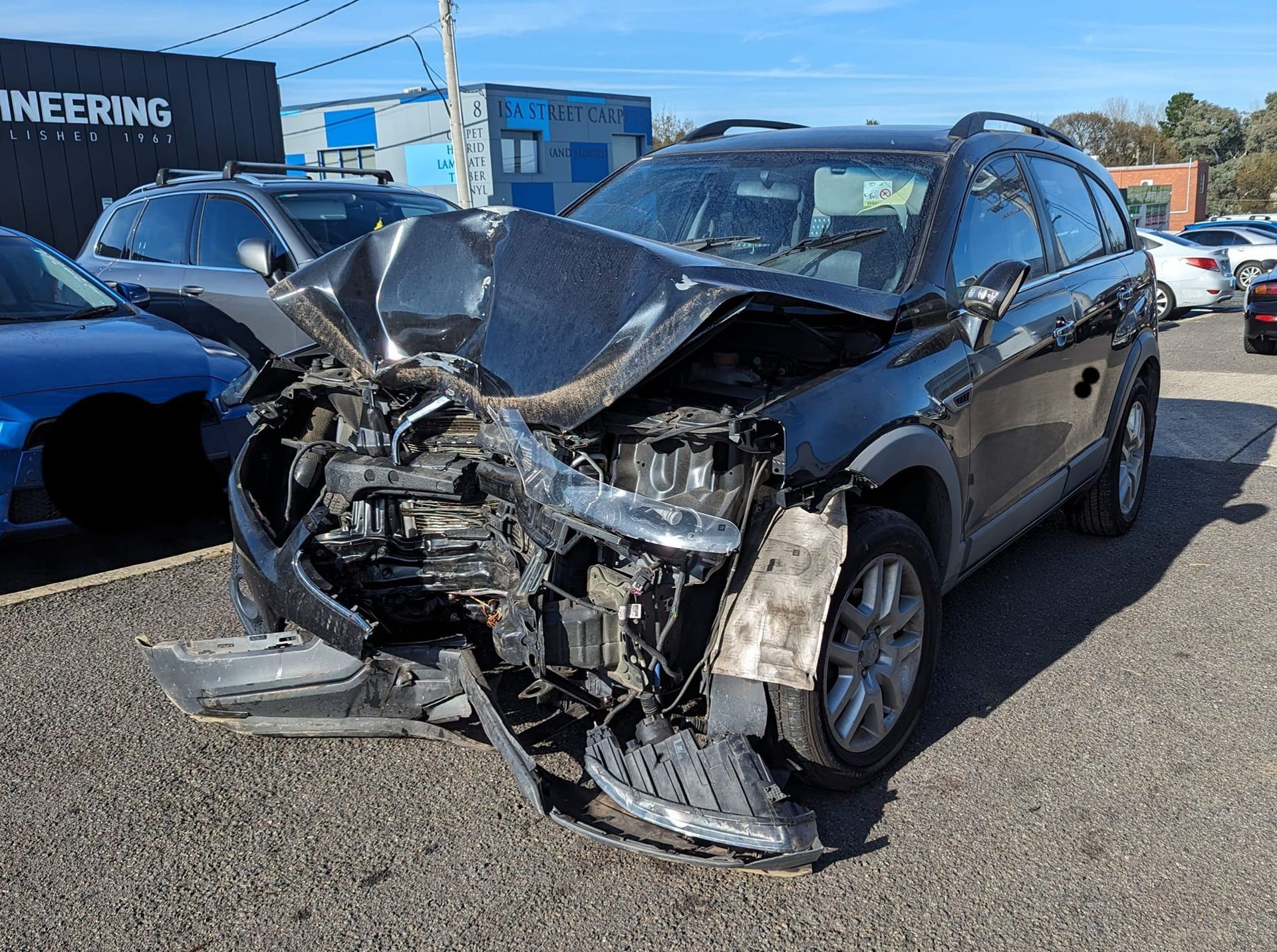 A Severely Damaged Black Car — Moto Bodyworks in Fyshwick, ACT