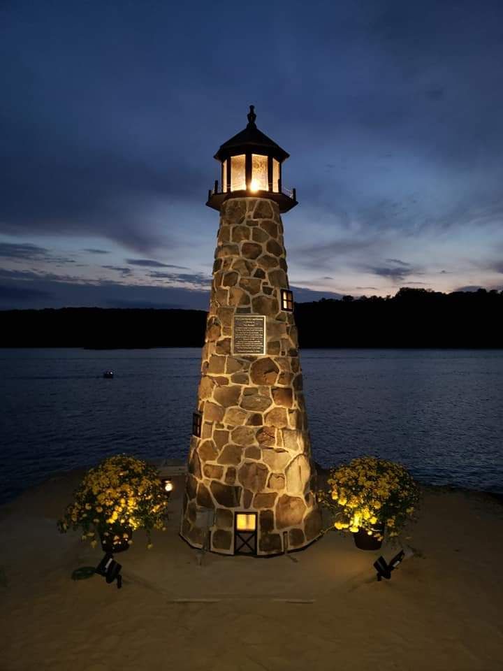 a black and white striped lighthouse on a beach
