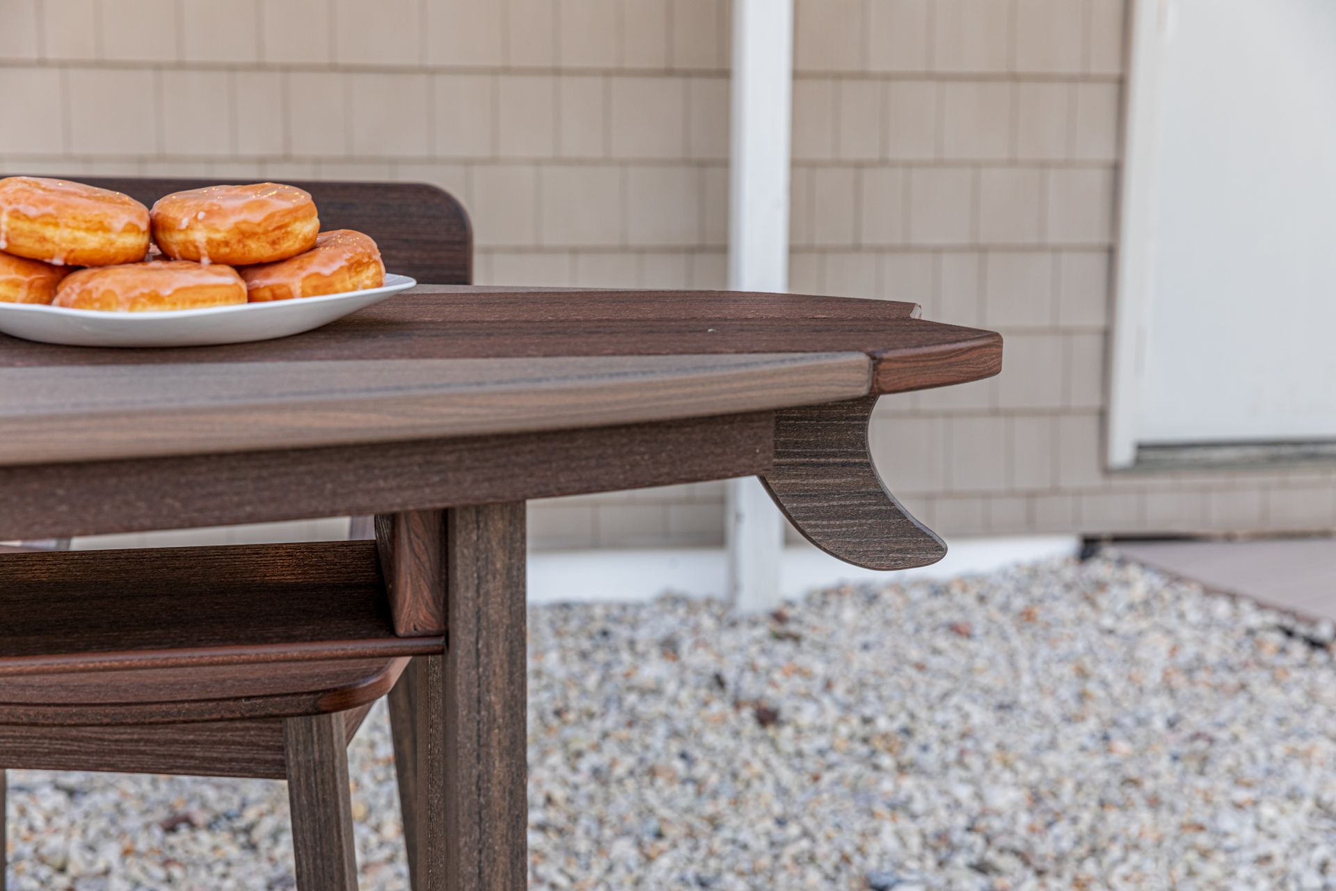 A wooden table with a plate of donuts on it.