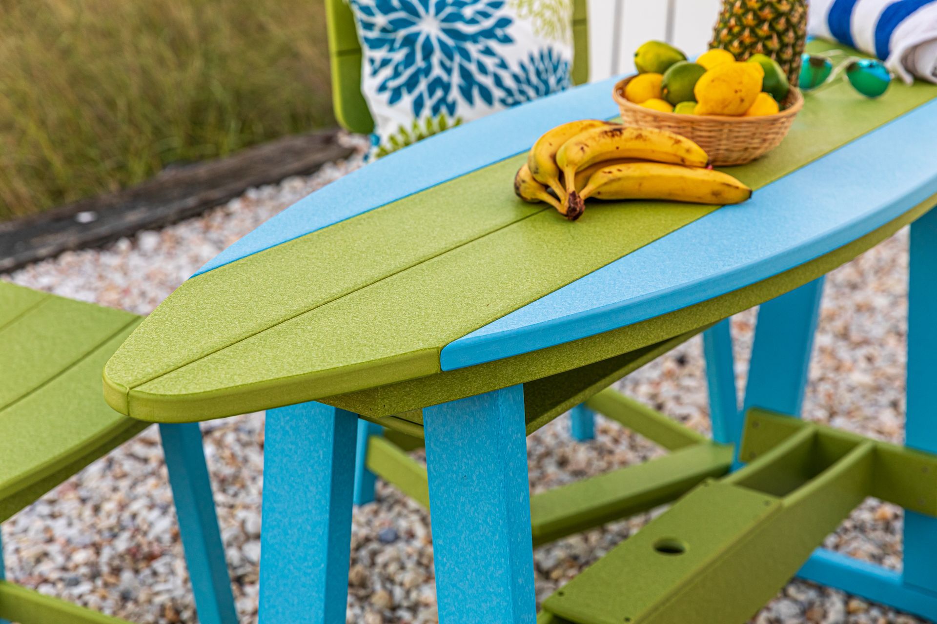 A blue and green surfboard table with bananas on it.