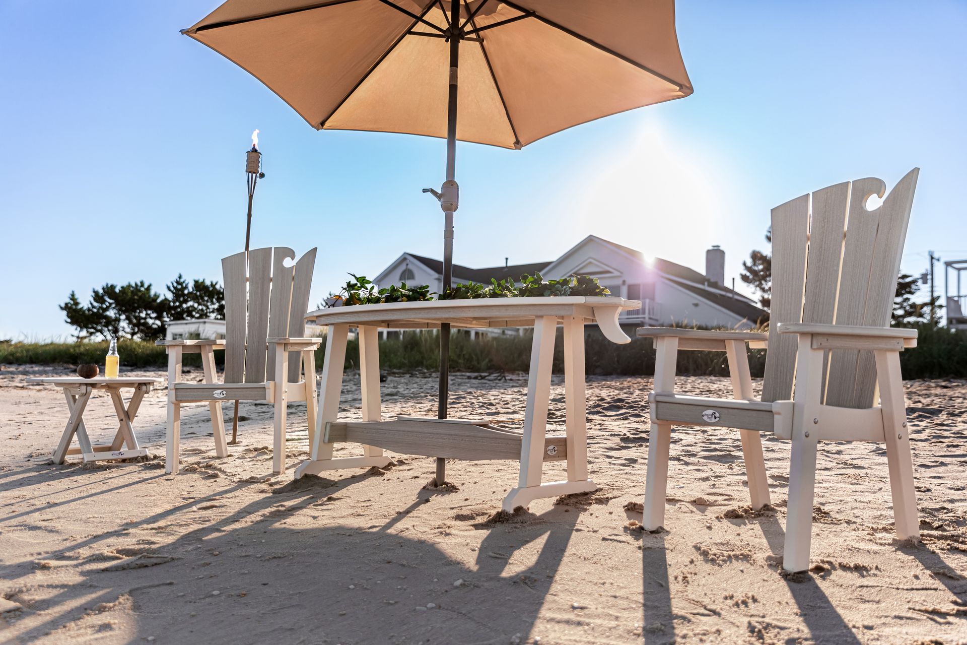 A table and chairs under an umbrella on the beach