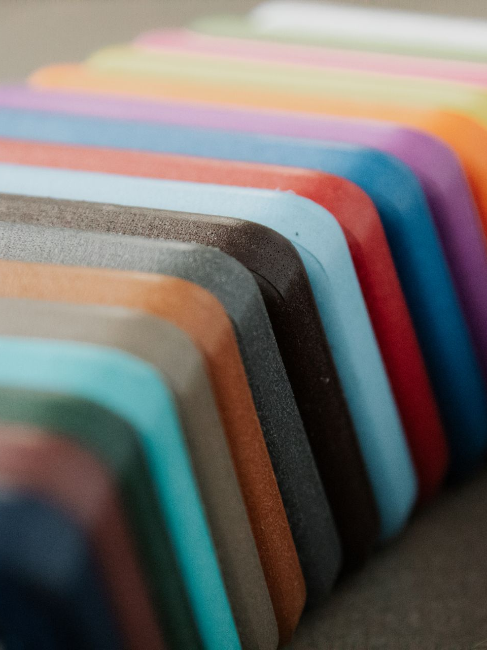 A row of rectangular blocks in a gradient of colorful shades, from dark blue to white, lined up at an angle.