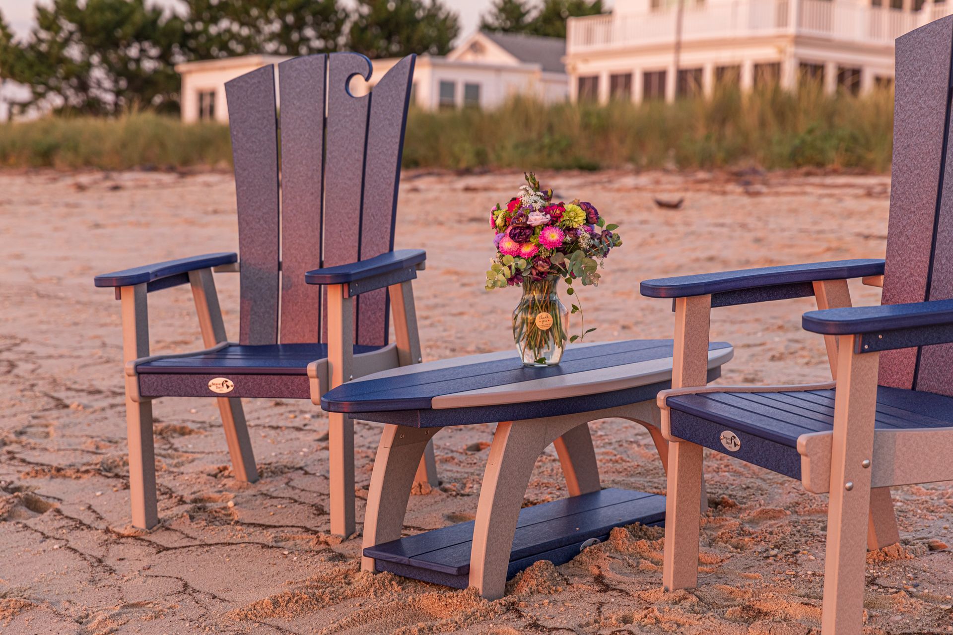 A row of wooden adirondack chairs sitting on top of a pile of gravel.