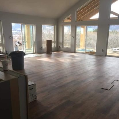 A large room with hardwood floors and lots of windows.