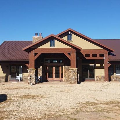 A large house with a brown roof and a car parked in front of it