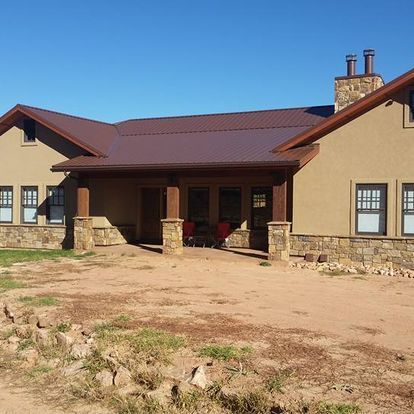 A house with a brown roof and a stone wall