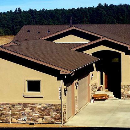 A house with a brown roof and a stone wall