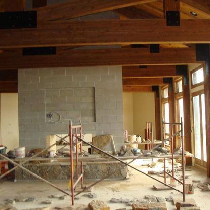 A room with a fireplace and scaffolding in it