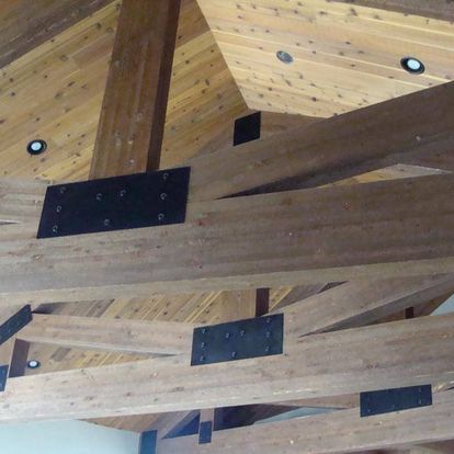 A ceiling with wooden beams and a metal bracket