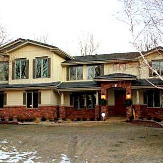 A large house with a lot of windows and a brick facade.