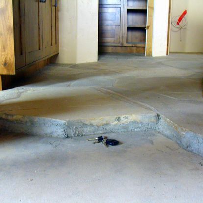 A pair of keys are laying on a concrete floor