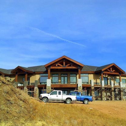 A large house with two trucks parked in front of it