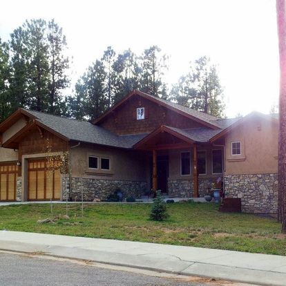 A house with a stone wall and a wooden roof