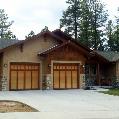 A house with two garage doors and a concrete driveway