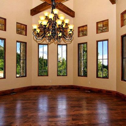 An empty room with a chandelier and lots of windows