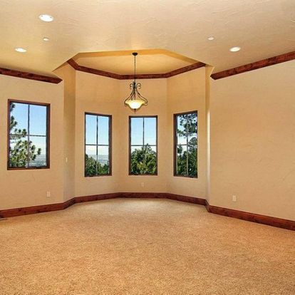 An empty room with a chandelier hanging from the ceiling