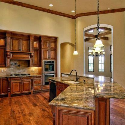 A kitchen with granite counter tops and wooden cabinets