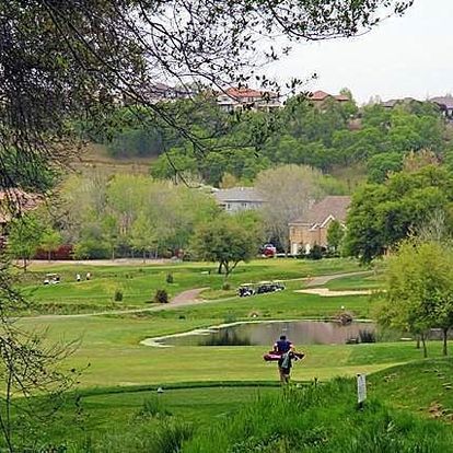 A man is carrying a golf bag on a golf course.