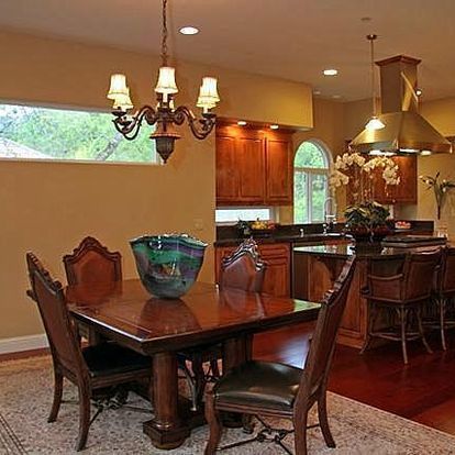 A dining room with a table and chairs and a chandelier