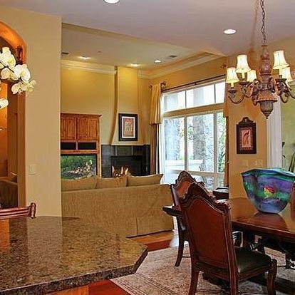 A living room with a table and chairs and a fireplace