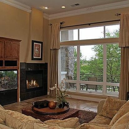 A living room with a fireplace and lots of windows