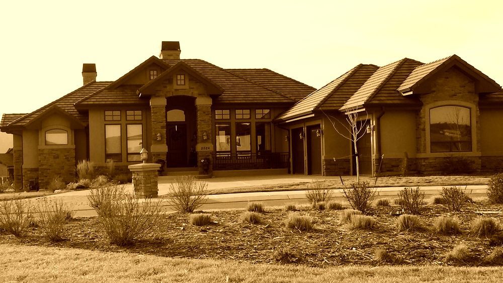 A large house is sitting in the middle of a field.