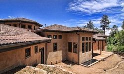 A large house with a tiled roof is sitting on top of a hill.