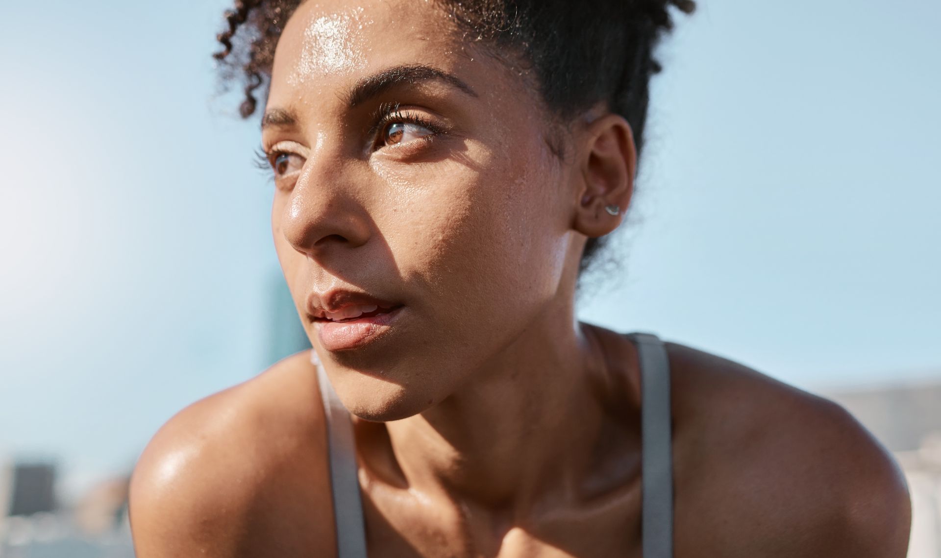 A close up of a woman 's face with sweat on her face.