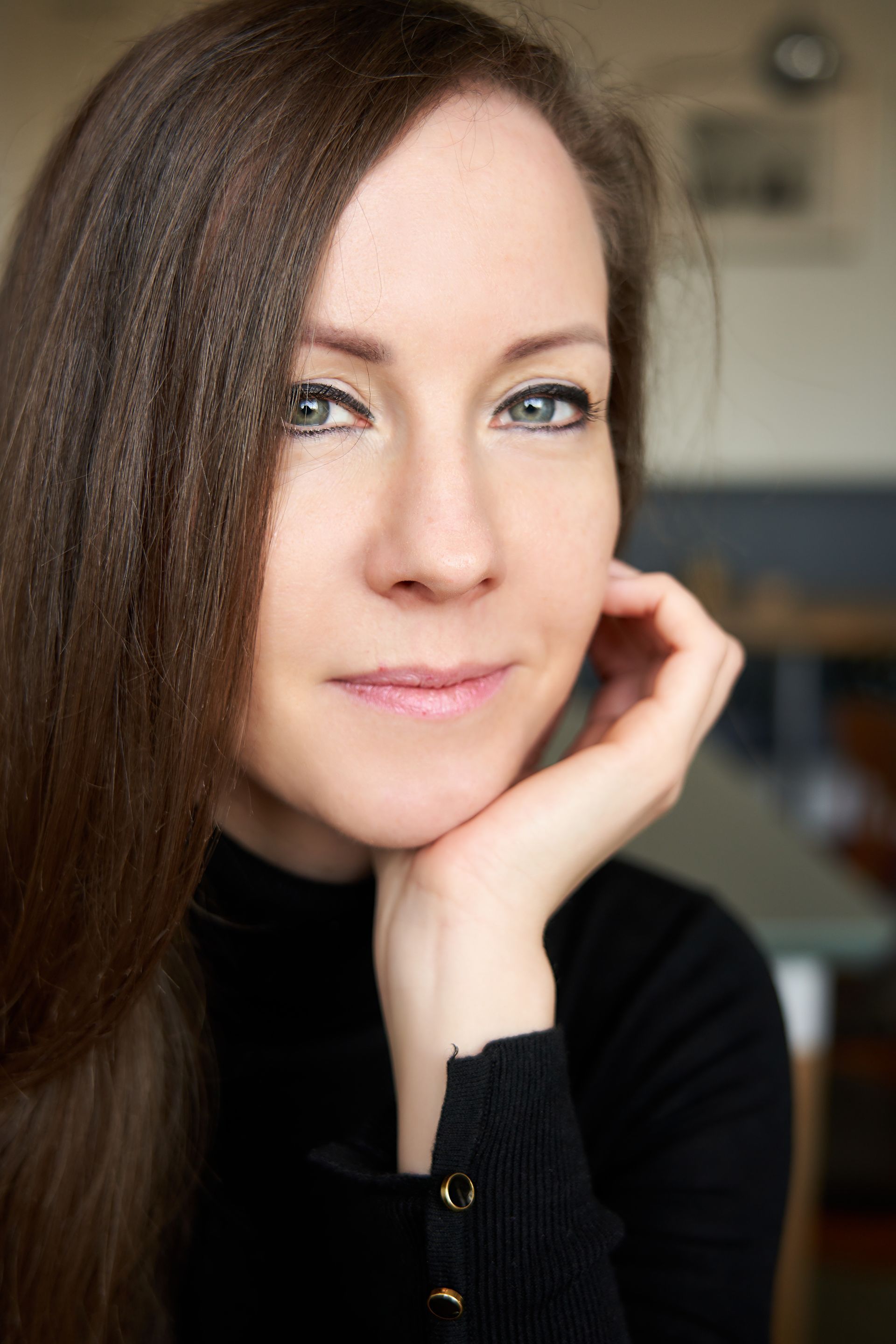 A close up of a woman 's face with her hand on her chin