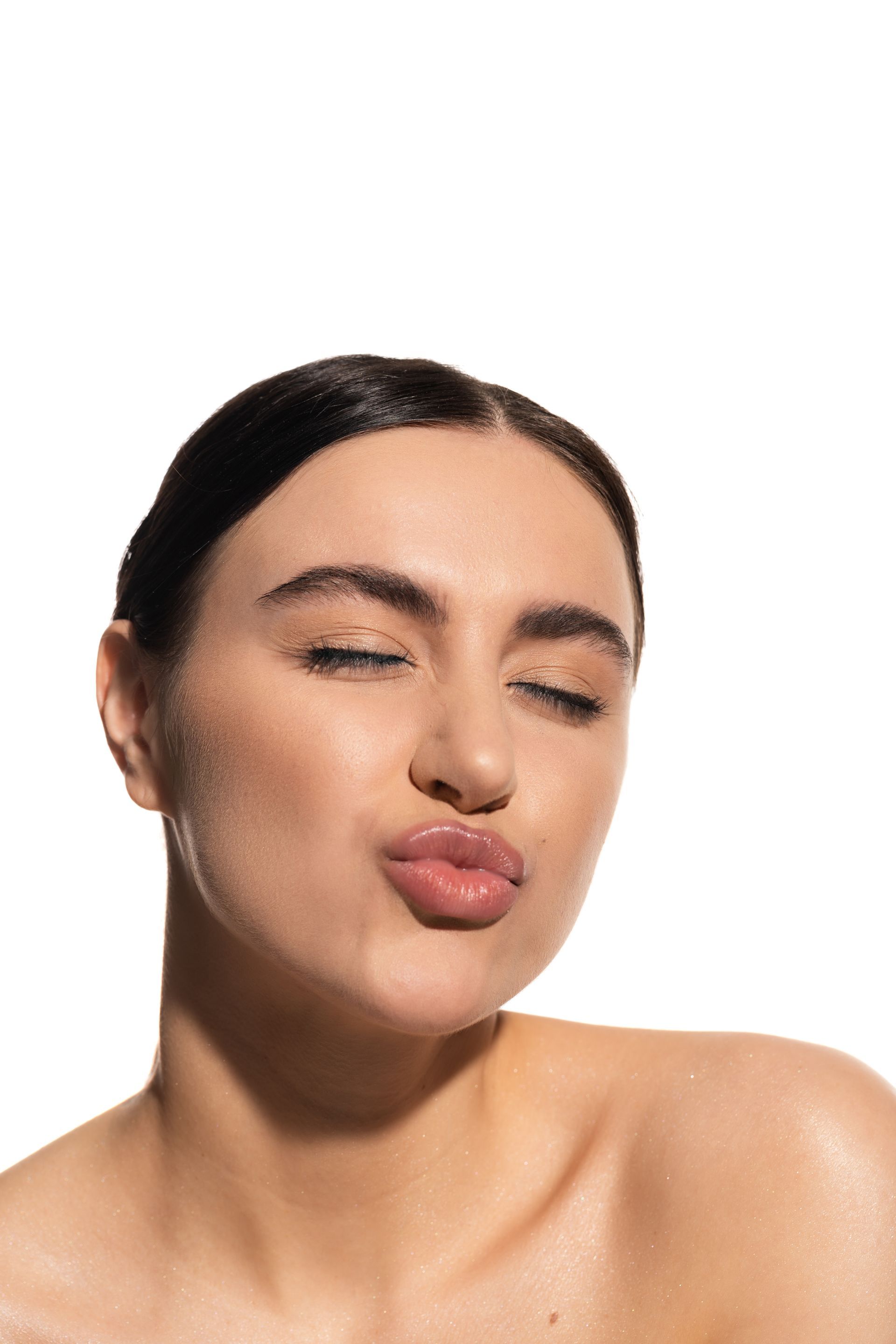 A close up of a woman making a funny face with her eyes closed.