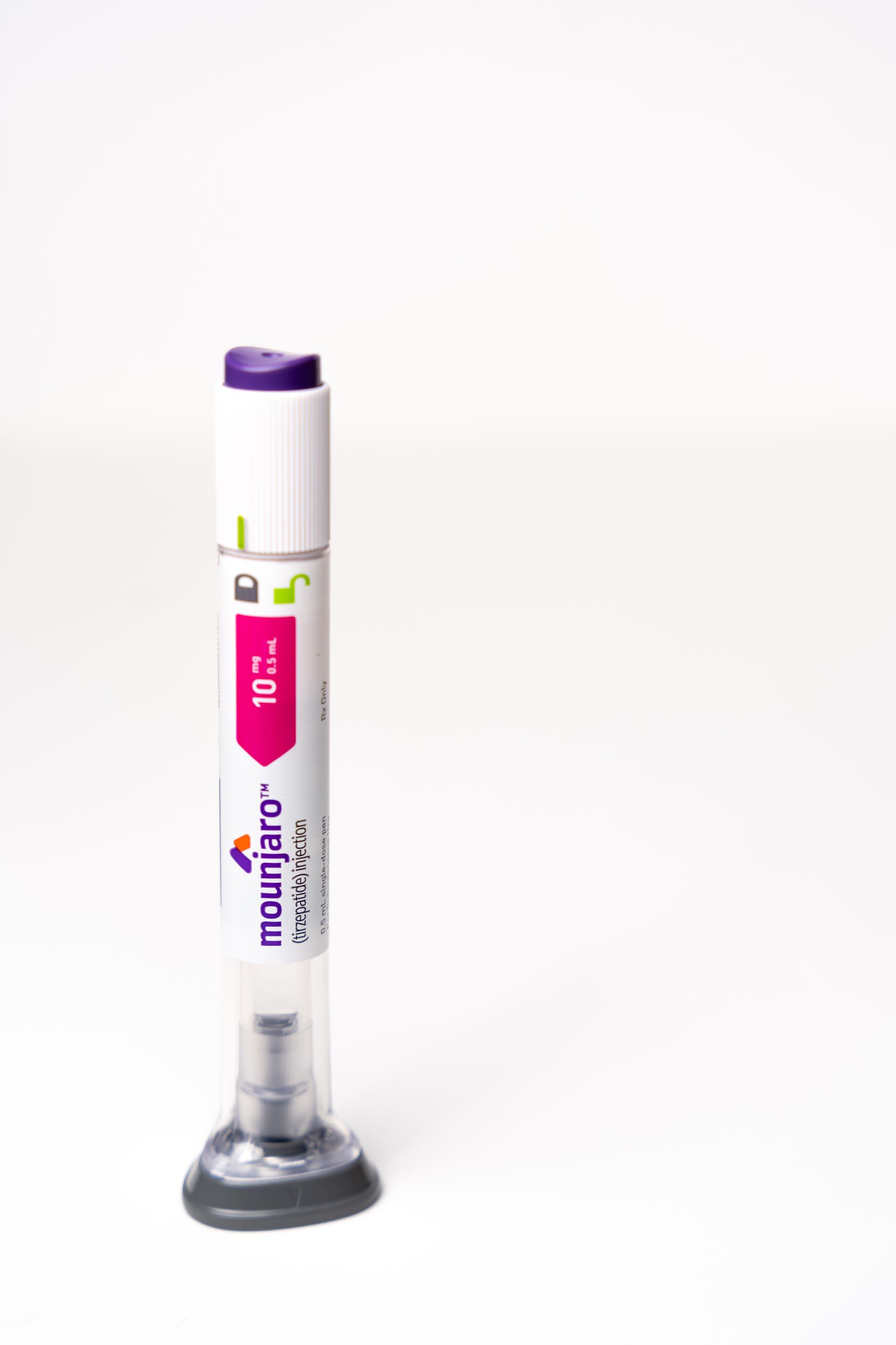 A purple and white pen is sitting on a white surface.
