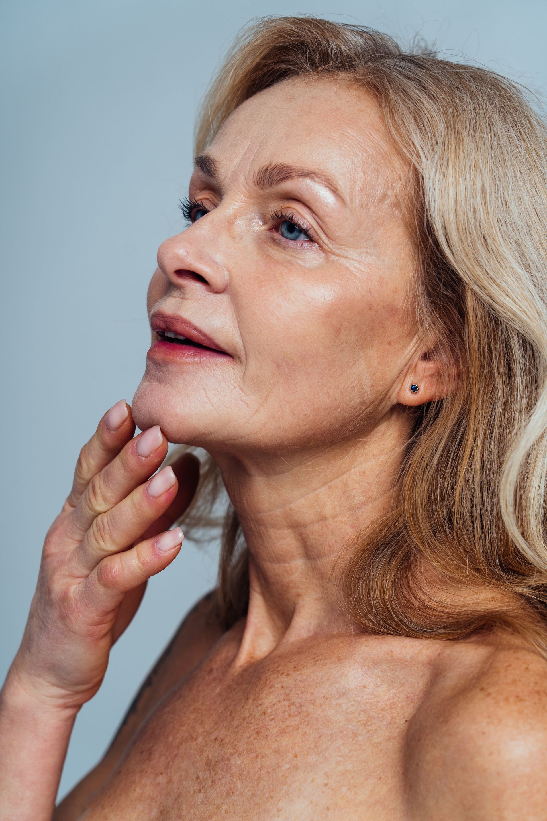 A close up of a woman 's face with her hand on her chin.