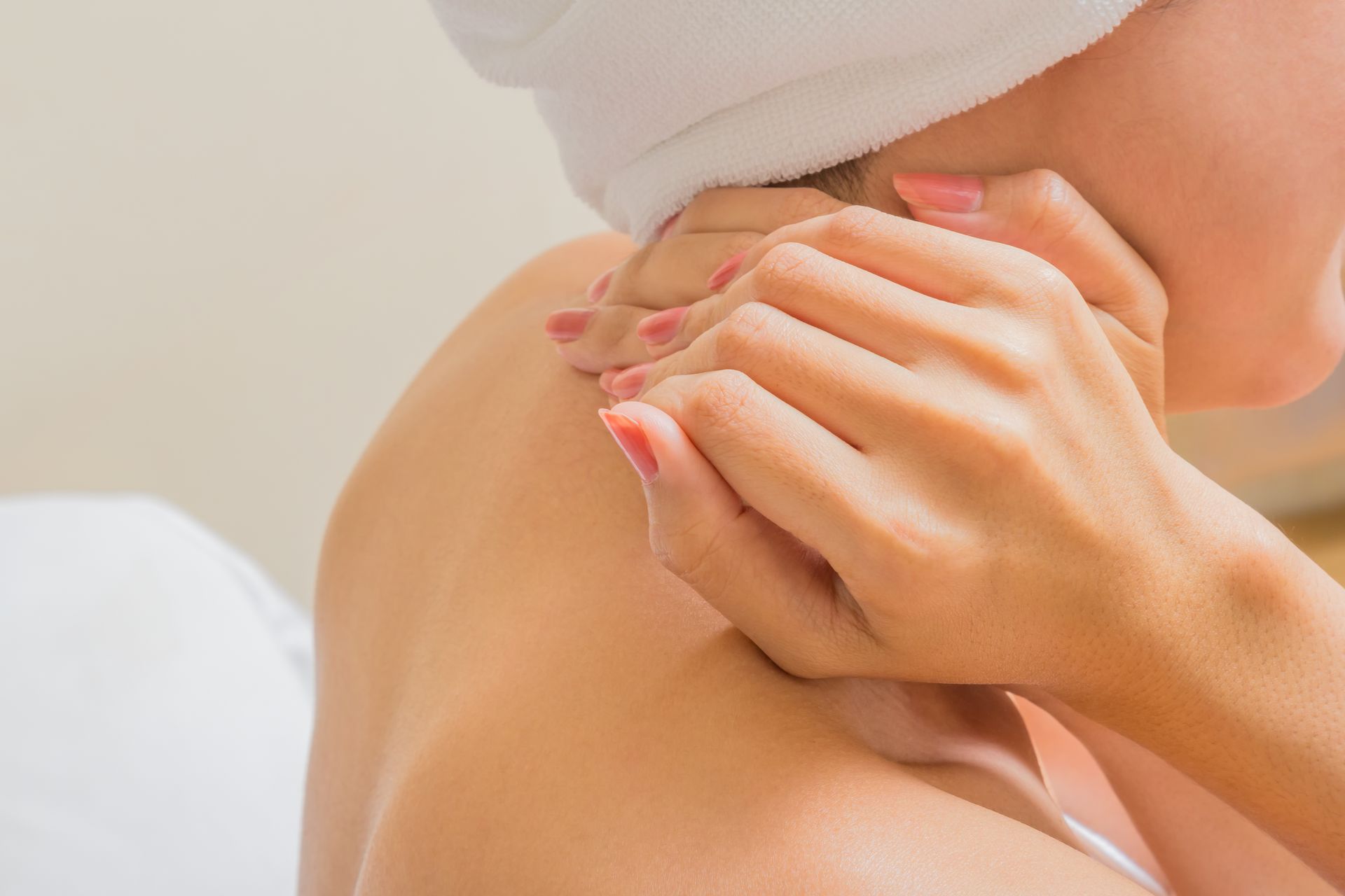 A woman with a towel wrapped around her head is getting a massage.