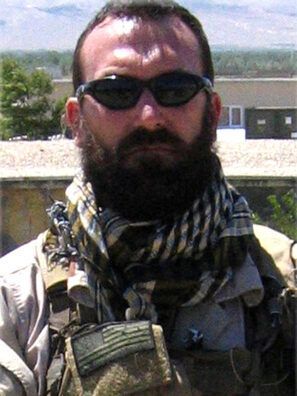 A man with a beard wearing sunglasses and a scarf