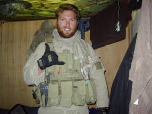 A man in a military uniform is giving a thumbs up