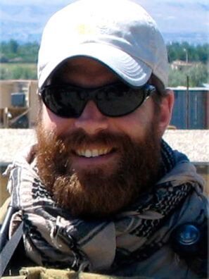 A man with a beard wearing sunglasses and a hat