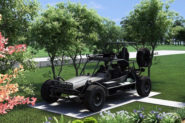 A buggy is parked in a grassy area surrounded by trees.