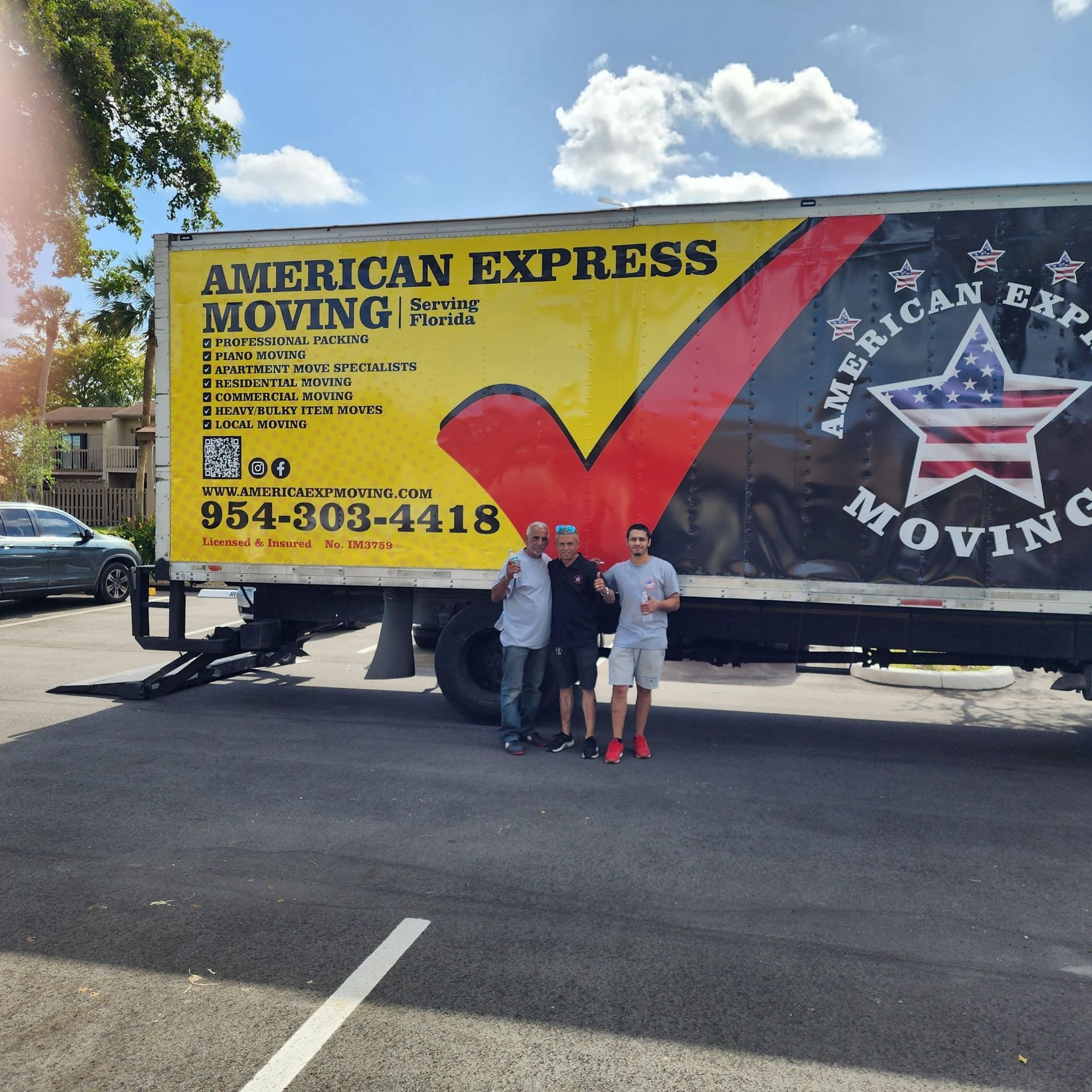 Man loading piano onto moving truck in front of a house. Call 954-303-4418.