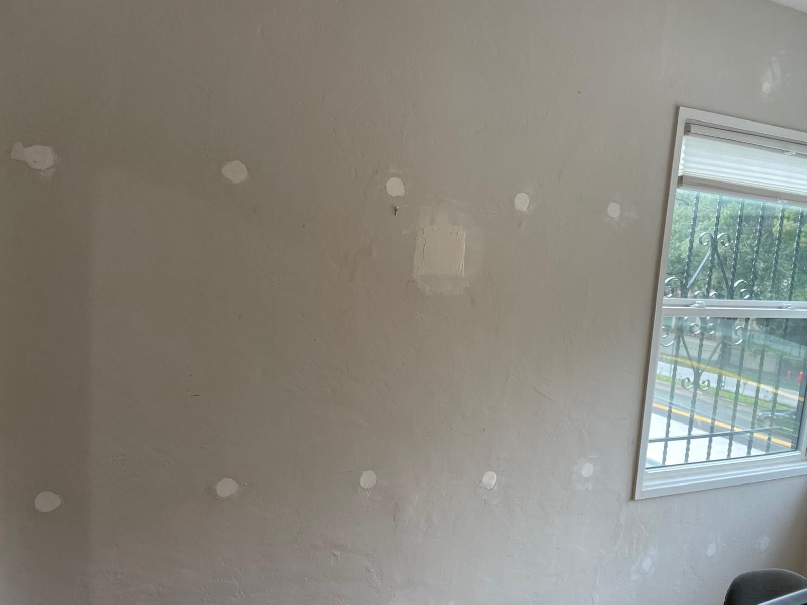 A room with a window and a gray wall.