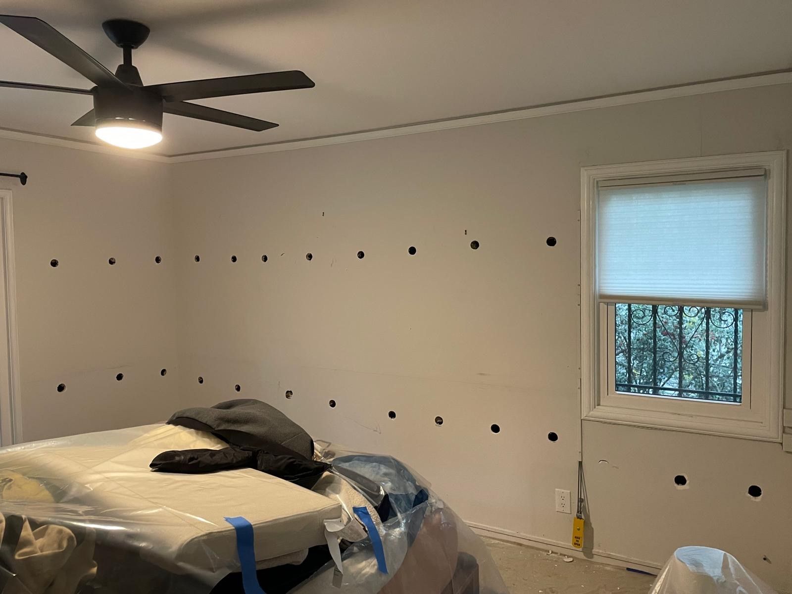 A bedroom with a bed , ceiling fan , and window.