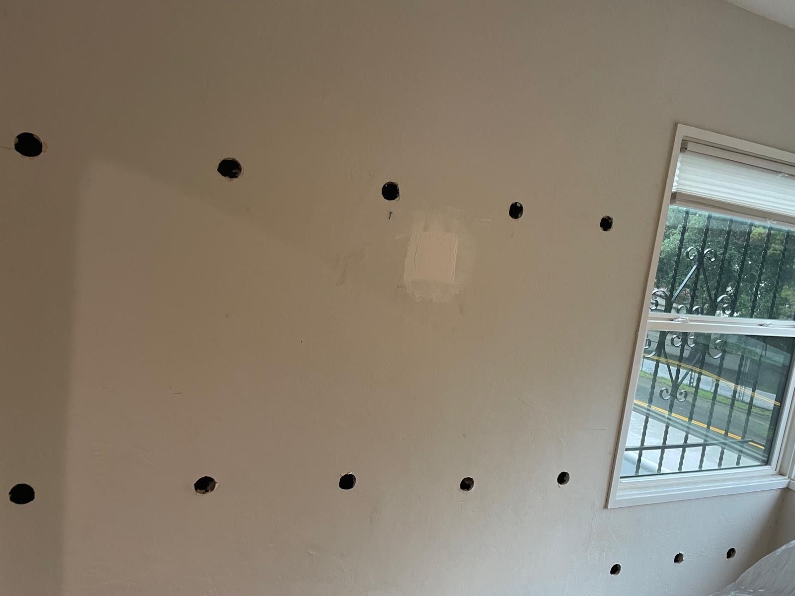 A man is laying insulation on a wooden floor.