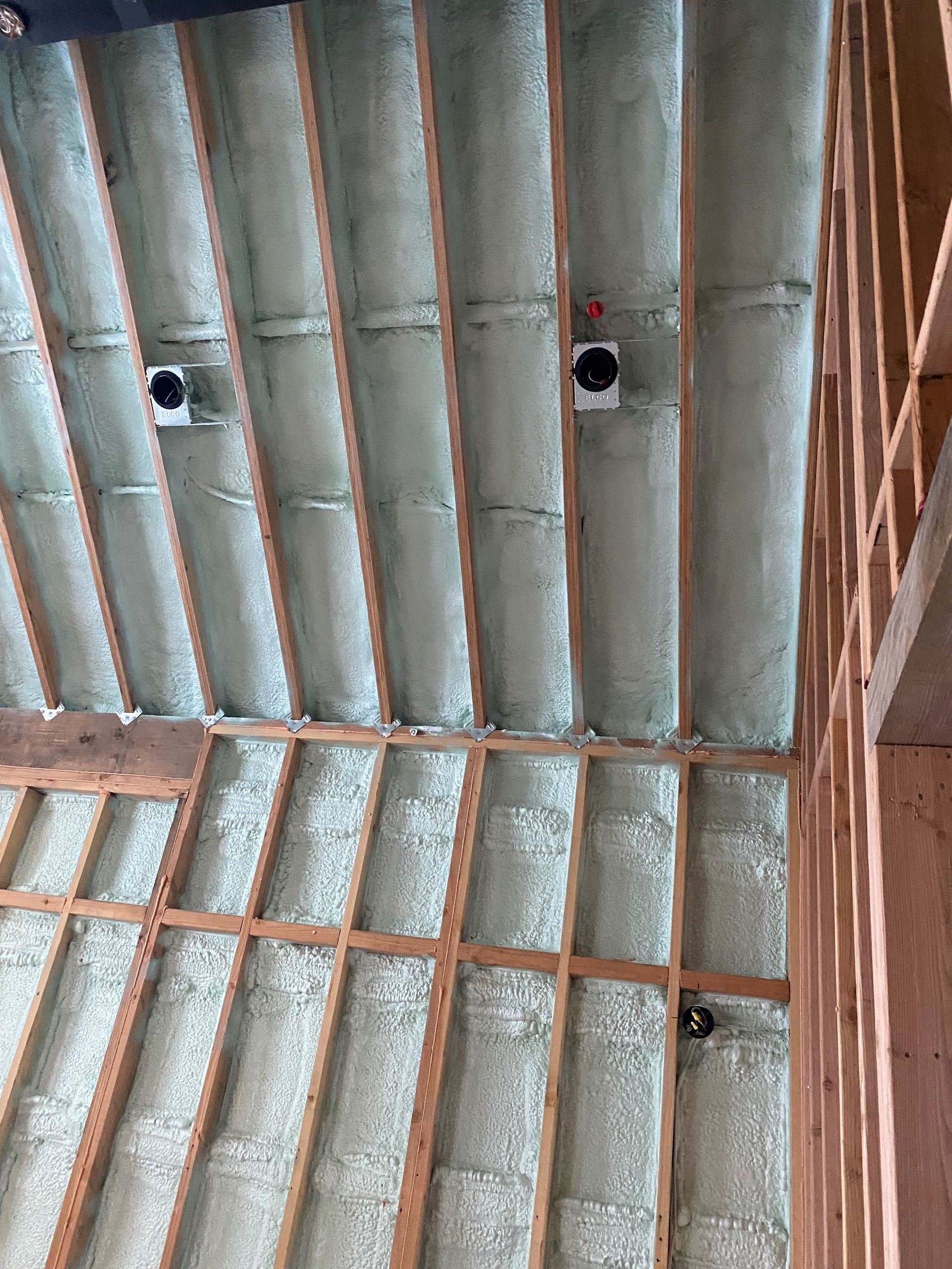 The ceiling of a building is insulated with spray foam.