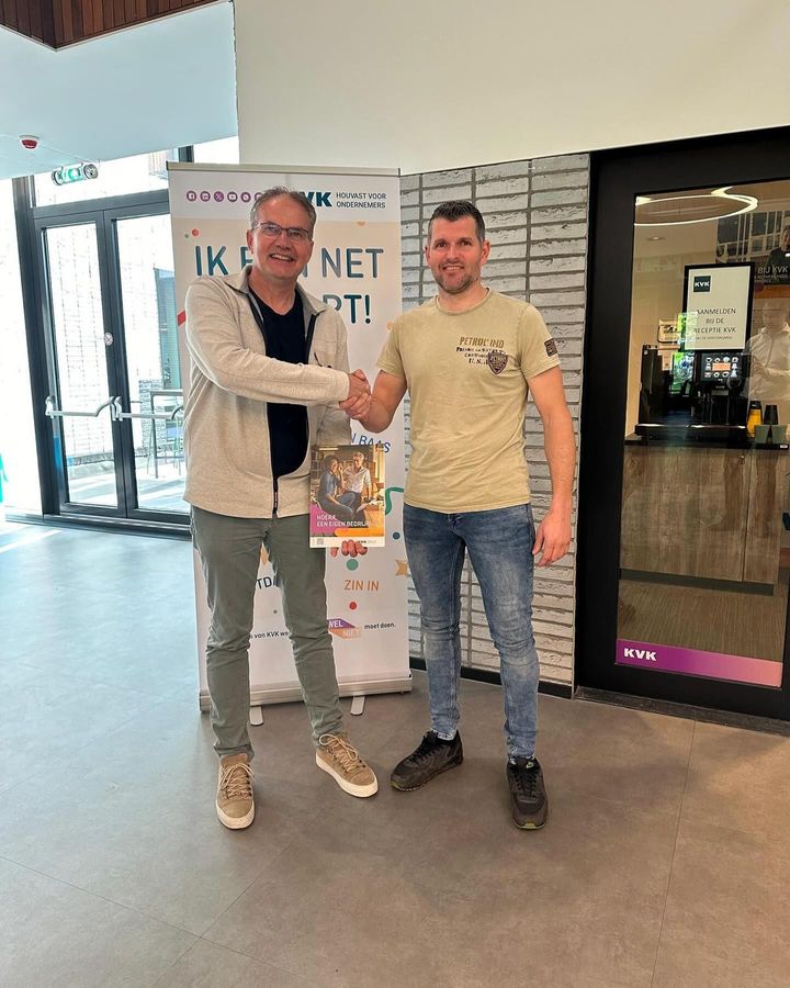 Twee mannen schudden elkaar de hand voor een bord.