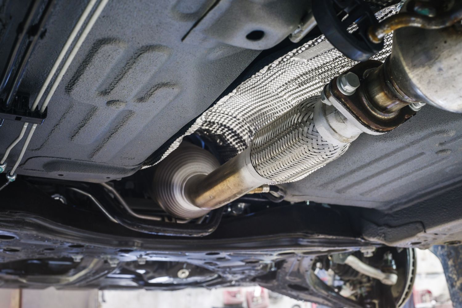 A close up of the underside of a car with a exhaust pipe | Hopkins Tire & Auto Service