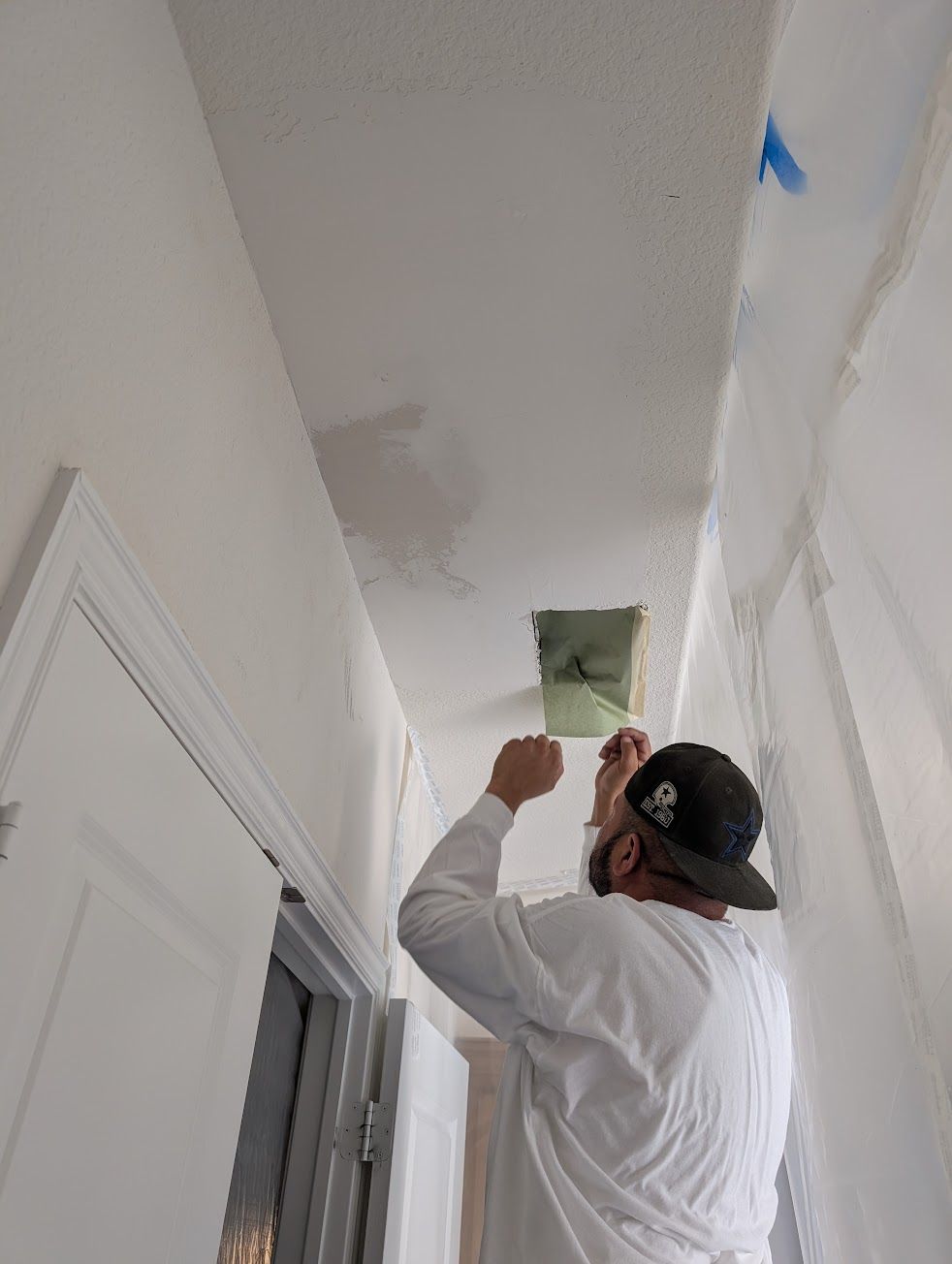 A man and a woman are measuring a wall with a level.