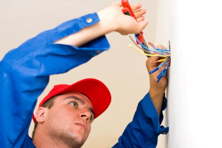 An expert technician performs electrical repair services by cutting cables for safe installations.